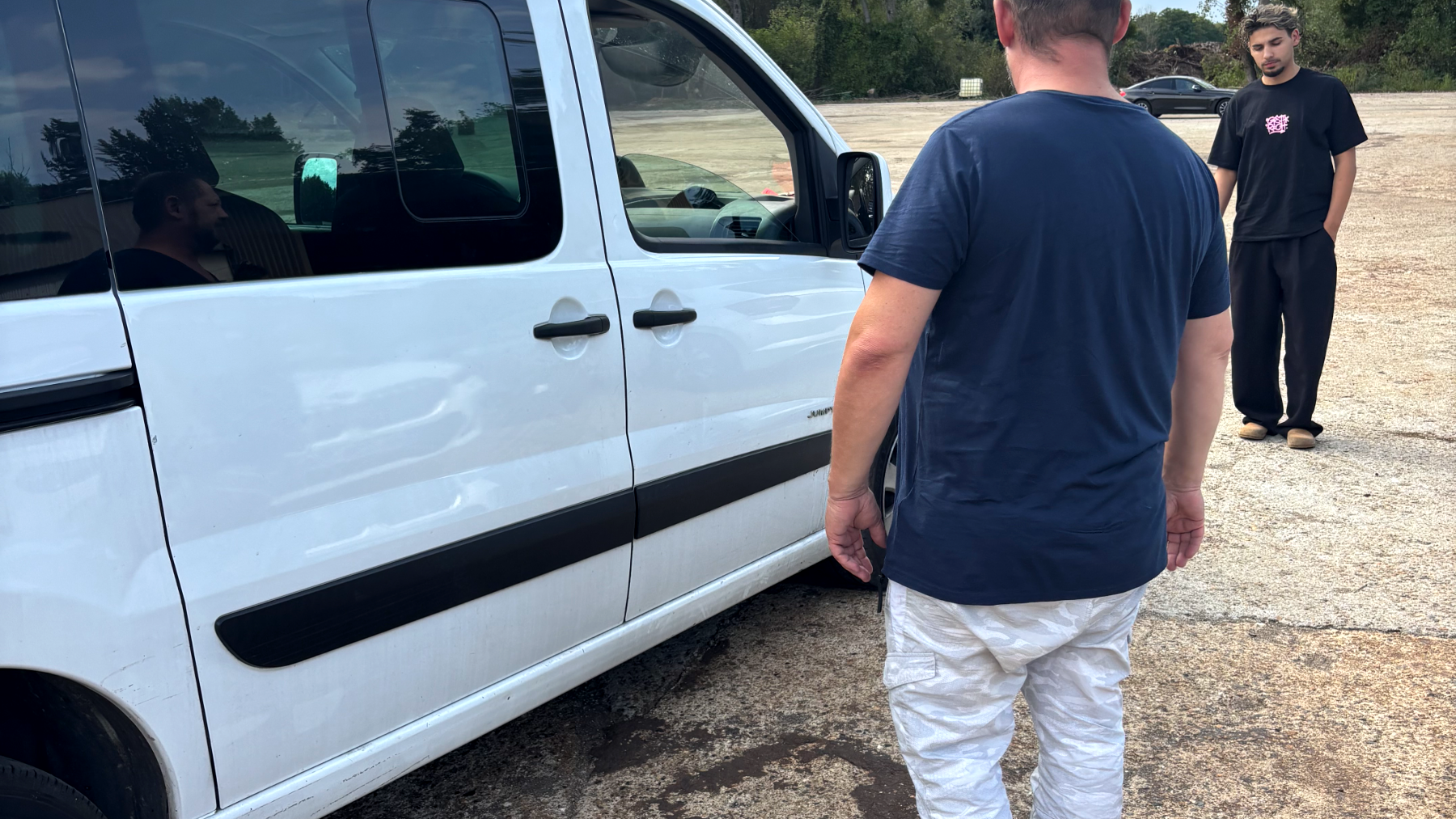 Un client et le chauffeur près de la navette Fly Park, prêts à partir vers l'aéroport